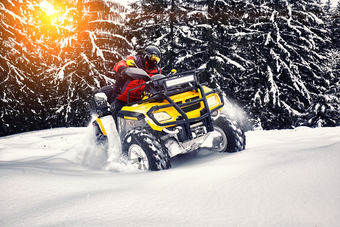 Person Riding Quad Bike on the Snow